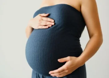 Mujer embarazada feliz tocando su vientre.