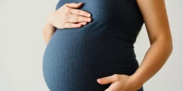 Mujer embarazada feliz tocando su vientre.