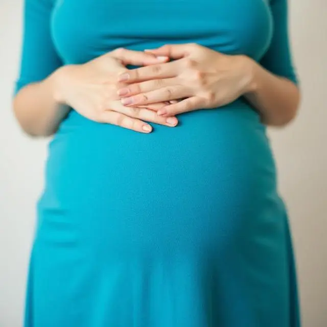 Mujer embarazada con vestido azul sosteniéndose el vientre