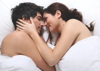 Pareja abrazada en la cama después de tener relaciones íntimas con fines reproductivos